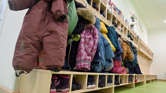 Jacken und Mäntel hängen an der Garderobe einer Kindertagesstätte. © picture alliance / SVEN SIMON 