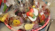 Süßigkeiten in Tüten liegen in einer Schale. © NDR Foto: Nils Hartung