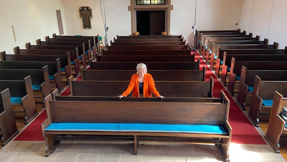 Pastorin Anne Mirjam Walter steht inmitten von Kirchenbänken. © NDR Foto: Wolfgang Kurtz