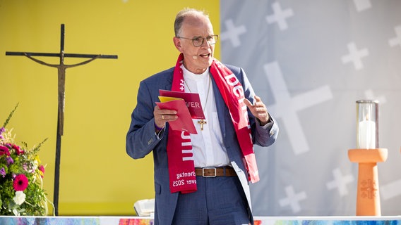 Landesbischof Ralf Meister spricht bei der Eröffnungsveranstaltung des Evangelischen Kirchentags 2025 in Hannover auf der Bühne vor dem Neuen Rathaus. © dpa Foto: Moritz Frankenberg