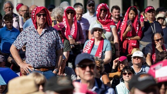 Hunderte Zuschauerinnen und Zuschauer verfolgen den Eröffnungsgottesdienst des Evangelischen Kirchentages 2025 in Hannover vor der Bühne vor dem Neuen Rathaus. © dpa Foto: Moritz Frankenberg