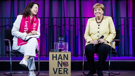 Altkanzlerin Angela Merkel (CDU) sitzt bei ihrem Besuch des 39. Deutschen Evangelischen Kirchentags neben Anja Siegesmund, Präsidentin des Evangelischen Kirchentags 2025. © dpa Foto: Moritz Frankenberg