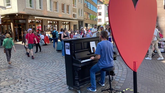 Ein Mann spielt beim Kirchentag in der Altstadt von Hannover Klavier. © NDR Foto: Sabine Pinkenburg