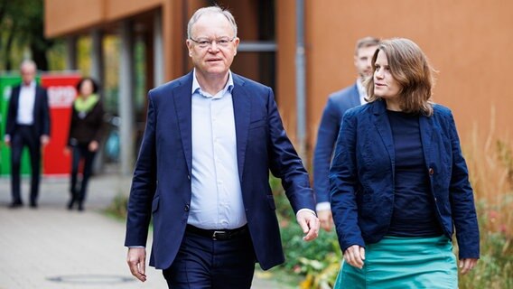 Stephan Weil (li, SPD) geht neben Julia Willie Hamburg (Grüne). (Sie sind auf dem Weg zu einem Pressestatement zum Beginn der Koalitionsverhandlungen.) © Michael Matthey/dpa Foto: Michael Matthey/dpa