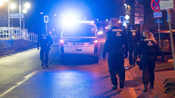 Einsatzkräfte der Polizei gehen bei Nacht am Leine Center in Laatzen in der Region Hannover auf einer Straße. (Archivbild vom 01.01.2022) © picture alliance/dpa Foto: Julian Stratenschulte
