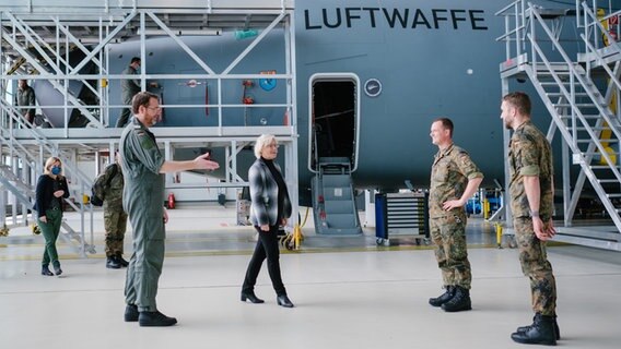 Bundesverteidigungsministerin Christine Lambrecht (SPD, M) und Oberst Christian John (l) begrüßen bei Lambrechts Besuch beim Lufttransportgeschwader 62 im niedersächsischen Wunstorf Soldaten vor einem A400M. © dpa-Bildfunk Foto: Ole Spata