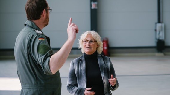 Bundesverteidigungsministerin Christine Lambrecht (SPD) spricht bei ihrem Besuch beim Lufttransportgeschwader 62 im niedersächsischen Wunstorf mit Oberst Christian John. © dpa-Bildfunk Foto: Ole Spata