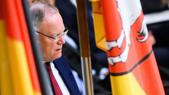 Stephan Weil (SPD), Ministerpräsident Niedersachsen, steht im niedersächsischen Landtag zwischen Fahnen. © Julian Stratenschulte/dpa Foto: Julian Stratenschulte