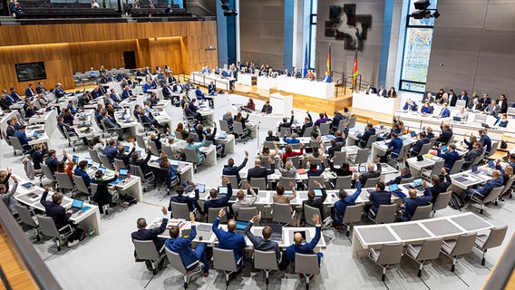 Abgeordnete heben bei einer Abstimmung während einer Sitzung vom niedersächsischen Landtag ihre Hand. © picture alliance/dpa | Moritz Frankenberg Foto: Moritz Frankenberg