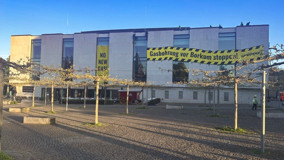 Aktivisten auf dem Landtag. An dem Gebäude hängt ein Transparent: "Gasbohrungen vor Borkum stoppen!" © NDR Foto: Sophie Mühlmann