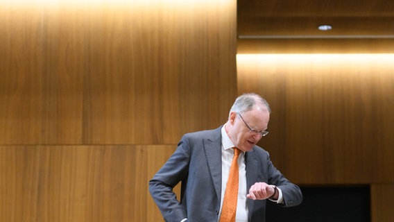 Stephan Weil (SPD), Ministerpräsident Niedersachsen, steht im niedersächsischen Landtag und schaut auf eine seine Uhr. © dpa-Bildfunk Foto: Julian Stratenschulte