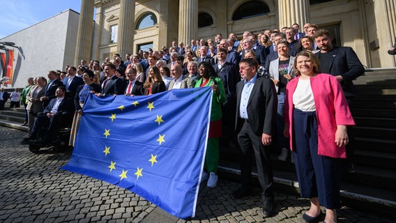 Abgeordnete von SPD, CDU und Bündnis 90/Die Grünen stehen mit einer Europaflagge vor dem niedersächsischen Landtag. © dpa Foto: Julian Stratenschulte