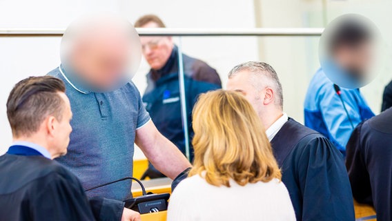 Die beiden Angeklagten stehen bei Prozessauftakt nach einem Mord in einem Autohaus in einem Saal vom Landgericht Hannover. © picture alliance/dpa | Moritz Frankenberg Foto: Moritz Frankenberg