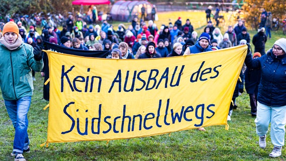 Demonstrierende halten ein Transparent mit der Aufschrift: "Kein Ausbau des Südschnellwegs". © Moritz Frankenberg/dpa 