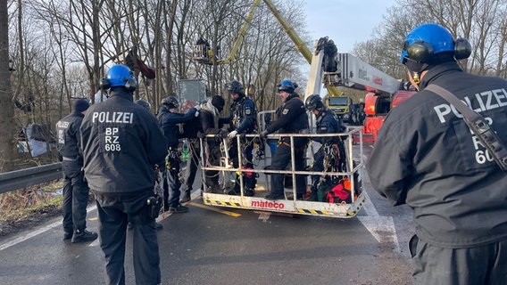 Ein Aktivist wird von der Polizei während der Räumung des Protestcamp "Tümpeltown" aus einem Kran begleitet. © NDR Foto: Kristoph Niels