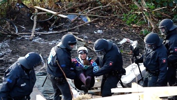 Einsatzkräfte der Polizei tragen eine Frau aus dem Protestcamp in der Leinemasch. © NEWS5 