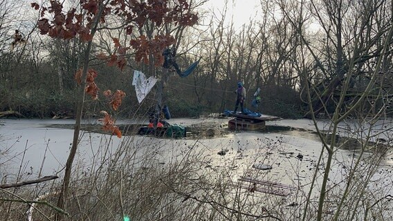 Aktivisten stehen während der Räumung des Protestcamp "Tümpeltown" auf einem Floß in der Leinemasch. © NDR Foto: Gino Egbers