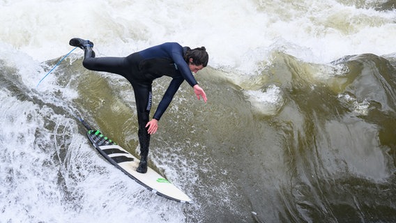 Ein Surfer testet die Leinewelle auf dem Fluss Leine in der Altstadt in Hannover. © dpa-Bildfunk Foto: Julian Stratenschulte/dpa