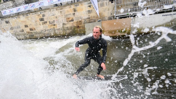 Ein Surfer testet die Leinewelle auf dem Fluss Leine in der Altstadt in Hannover. © dpa-Bildfunk Foto: Julian Stratenschulte/dpa