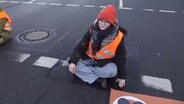 Aktivisten der "Letzten Generation" kleben sich an die Straße am Deisterkreisel in Hannover. © NonstopNews 