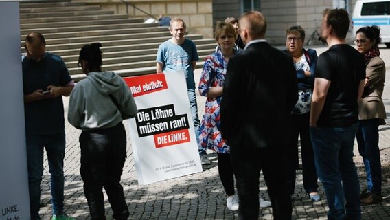 Ein Wahlplakat für die Landtagswahl der Partei die Linke mit der Aufschrift: "Die Löhne müssen rauf!" steht vor dem niedersächsischen Landtag während der Vorstellung der Landtagswahlkampagne der Linken. © Ole Spata/dpa Foto: Ole Spata