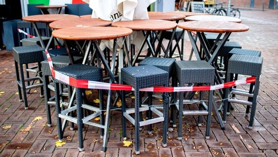 Tische und Stühle stehen vor einer Pizzeria auf der Lister Meile, die derzeit nur Speisen zum Mitnehmen anbieten kann. © dpa-Bildfunk Foto: Hauke-Christian Dittrich/dpa