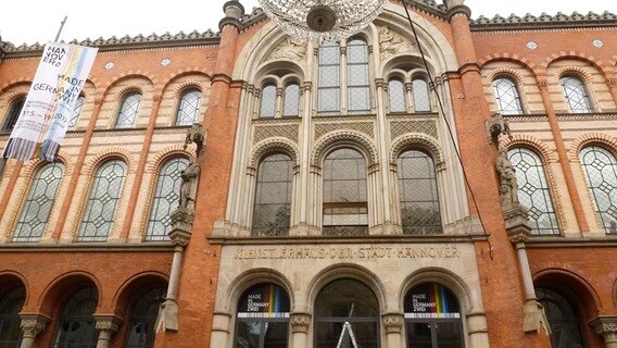 Vor einem roten Gebäude hängt ein Kronleuchter. Über dem Eingang steht in goldenen Lettern "Küntlerhaus der Stadt Hannover". © NDR.de Foto: Norbert Bourgeon