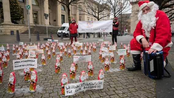 Weihnachtsmänner aus Schokolade stehen bei einer Mahnwache der Gewerkschaft Erziehung und Wissenschaft (GEW) vor dem niedersächsischen Landtag. © dpa-Bildfunk Foto: Julian Stratenschulte
