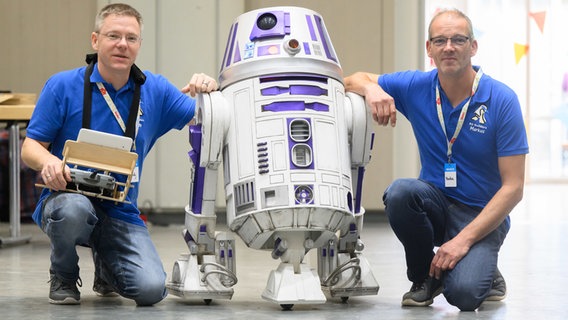 Zwei Erfinder sitzen neben einem selbst-gebauten Roboter aus Star Wars. © picture alliance/dpa | Julian Stratenschulte Foto: Julian Stratenschulte
