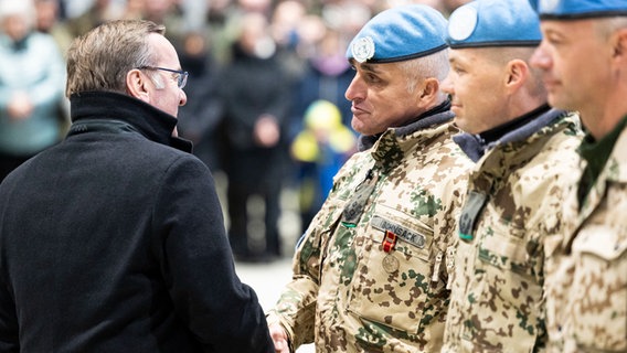 Verteidigungsminister Boris Pistorius zeichnet Oberst Heiko Bohnsack mit einer Einsatzmedaille bei einem Rückkehrerappell in einem Hangar auf dem Gelände vom Fliegerhorst Wunstorf aus. © dpa-Bildfunk / dpa Foto: Michael Matthey