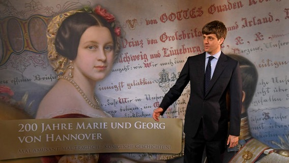 Ernst August von Hannover Junior steht vor dem Plakat einer Ausstellung auf Schloss Marienburg. © dpa-Bildfunk Foto: Holger Hollemann