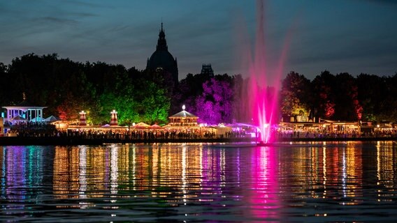 Menschen sitzen in beleuchteten Pavillons am Nordufer des Maschsees in Hannover. © Hannover Marketing und Tourismus GmbH Foto: Rainer Jensen