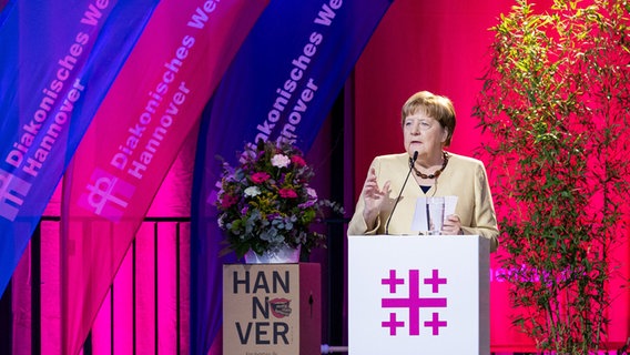 Altkanzlerin Angela Merkel spricht bei ihrem Besuch des Deutschen Evangelischen Kirchentages auf einem Podium. © dpa Foto: Moritz Frankenberg