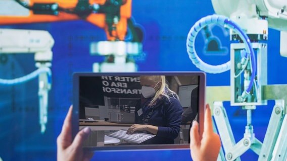 Eine Frau hält eine Computertastatur auf dem Stand der Fraunhofer-Gesellschaft bei der Hannover Messe 2022, gesehen auf dem Display eines Tablets. © Friso Gentsch/dpa Foto: Friso Gentsch