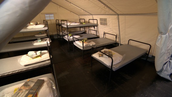 Betten stehen in einem Zelt. © NDR 