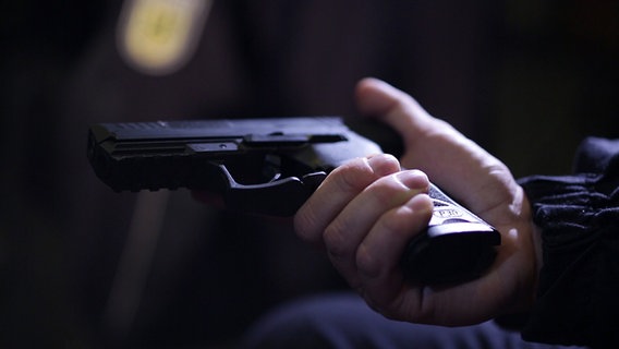Ein Revolver in einer Hand (nachgestellte Szene). © NDR 