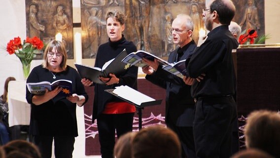 Sänger eines Kirchenchors singen aus ihren Gesangbüchern.  Foto: Andreas Rabe