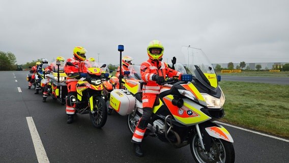 Mitglieder der Johanniter-Motorradstaffel fahren gemeinsam eine Straße entlang. © NDR Foto: Bernd Reiser
