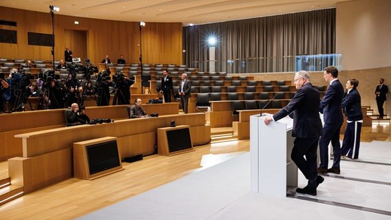 Journalisten stehen und sitzen im Auditorium vom Schloss Herrenhausen während der Abschluss-Pressekonferenz zur Ministerpräsidentenkonferenz mit Hendrik Wüst (2.v.r, CDU), Ministerpräsident von Nordrhein-Westfalen, und Stephan Weil (3.v.r, SPD), Ministerpräsident von Niedersachsen. © dpa-Bildfunk Foto: Michael Matthey