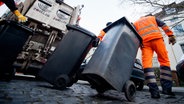 Mitarbeiter des Zweckverbands Abfallwirtschaft Region Hannover holen in Hannover Mülltonnen für Haushaltsmüll ab. (Archiv) © picture alliance/dpa Foto: Julian Stratenschulte