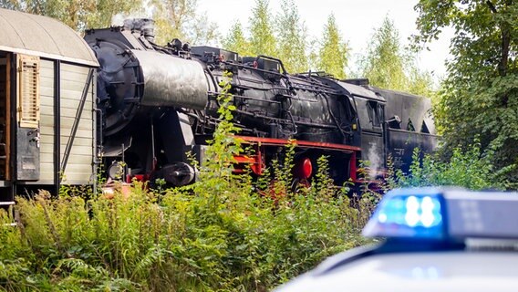 Eine Museumseisenbahn steht nach einem Unfall mit einem Traktor hinter einem Einsatzfahrzeug der Polizei. Ein Traktor und die Museumseisenbahn waren zusammengestoßen. © Moritz Frankenberg/dpa Foto: Moritz Frankenberg/dpa