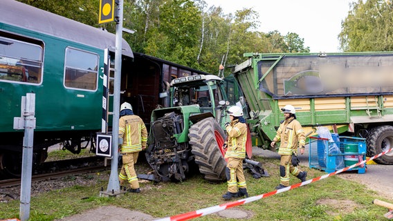 Ein Traktor mit Anhänger steht in Gifhorn nach einem Unfall mit einer Museumseisenbahn vor dieser. © Moritz Frankenberg/dpa Foto: Moritz Frankenberg/dpa