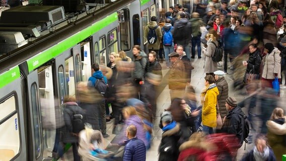 Menschen stehen auf einem Bahnsteig in der U-Bahnstation Kröpke in Hannover und steigen in eine Bahn ein. © dpa - Bildfunk Foto: Lucas Bäuml