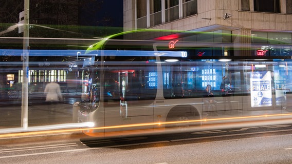 In Hannover ist auf einer Langzeitaufnahme ein Linienbus der GVH zu sehen, durch den der Hintergrund durchschimmert. © picture alliance Foto: Julian Stratenschulte