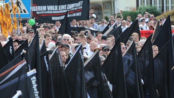 Neonazis stehen nach ihrem Aufmarsch für eine Kundgebung vor dem Wincklerbad in Bad Nenndorf. © dpa Foto: Bernd von Jutrczenka