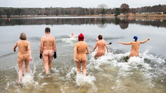 Nackte Schwimmer laufen beim 7. Neujahrs-Nackt-Schwimmen in den Sonnensee. © dpa Foto: Julian Stratenschulte