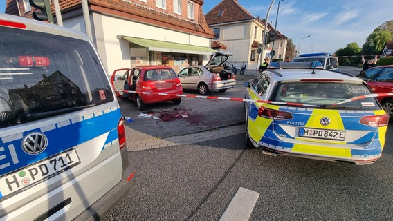 Polizeifahrzeuge stehen am Tatort. Bei einer Messerstecherei vor einer Pizzeria in Neustadt am Rübenberge ist ein Mann ums Leben gekommen. © picture alliance/dpa/TNN 