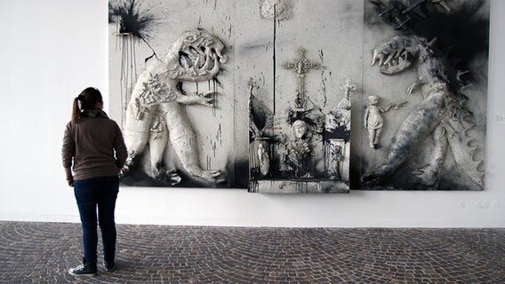 EinTryptichon der Künstlerin Niki de Saint Phalle. Auf dem Altarbild sind Monster und Kruzifize zu sehen, beide mit schwarzer und weißer Farbe besprüht. © Sprengel Museum Hannover Foto: Herling/Gwose/Werner