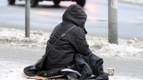Bei Minustemperaturen sitzt eine Obdachlose in der schneebedeckten Fußgängerzone von Hannover. © dpa Foto: Holger Hollemann