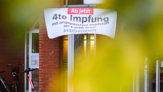 Ein Banner "Ab jetzt vierte Impfung mit angepassten Impfstoff" hängt am Impfzentrum am Landtag. © dpa-Bildfunk Foto: Julian Stratenschulte